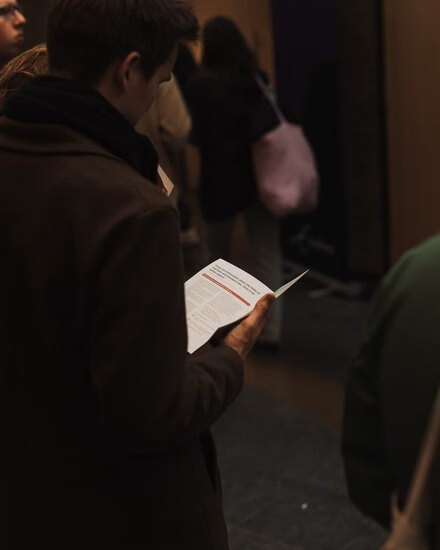 Aankomend student kijkt in informatieboekje tijdens de Master Open Dag.