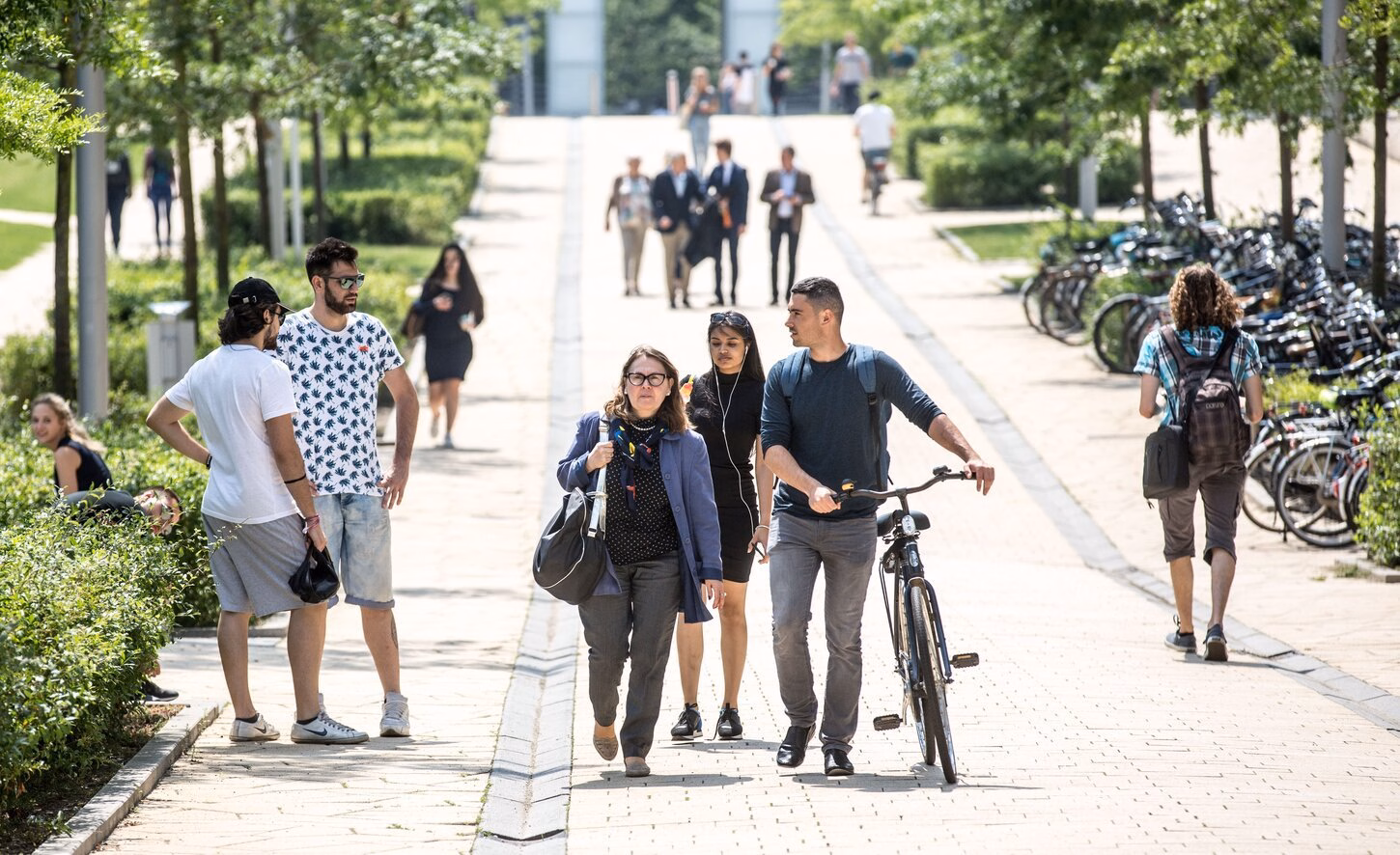 Students walking on campus with a bike