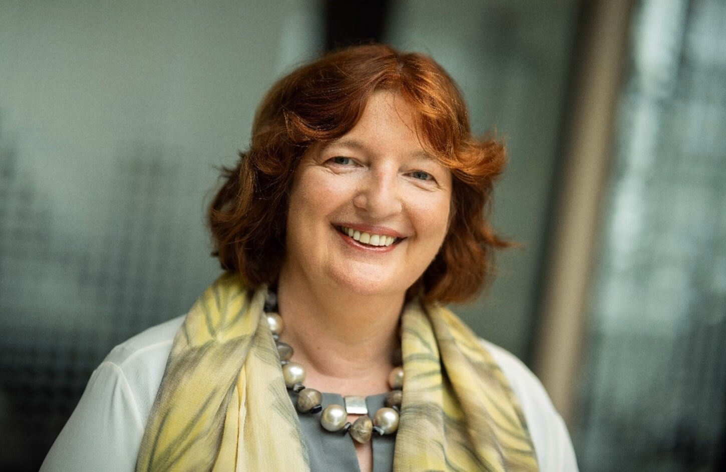 Ellen van Schoten kijkt met een vriendelijke lach in de camera.