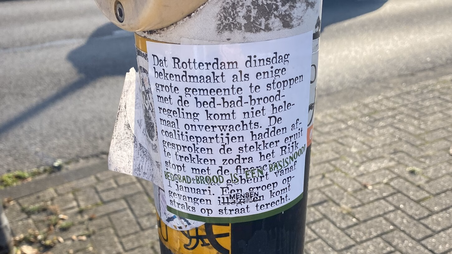 Protest kaartje bed-bad-brood-regeling op een stoplicht in Rotterdam.