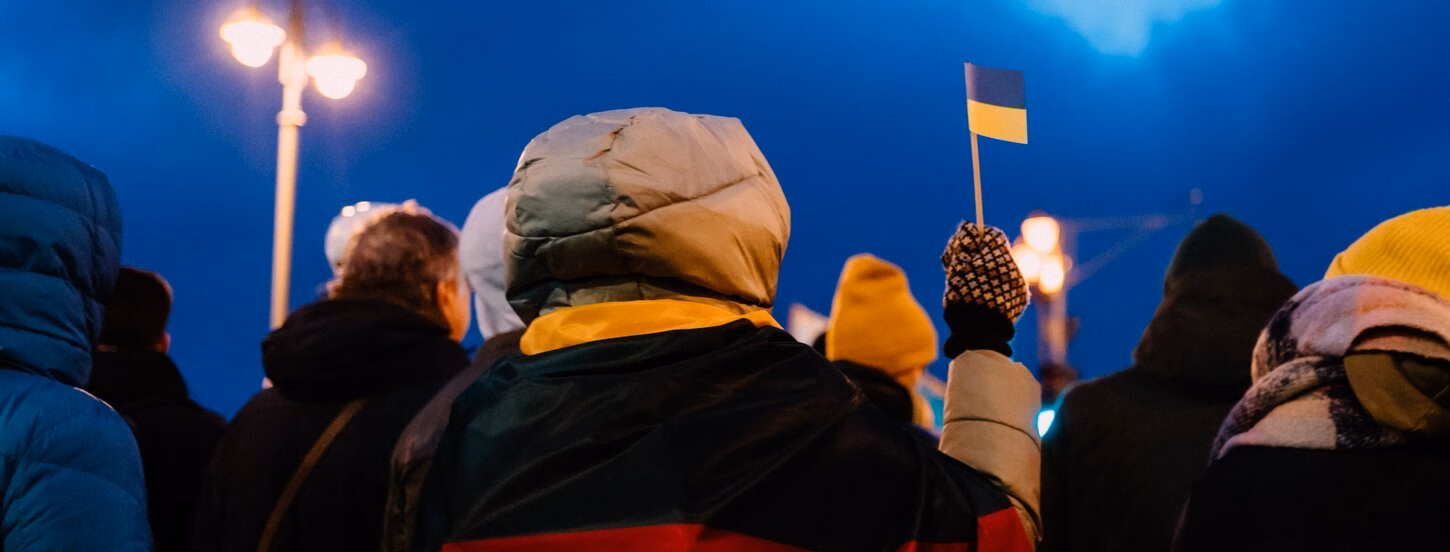 Woman holding a small Ukranian flag in the cold