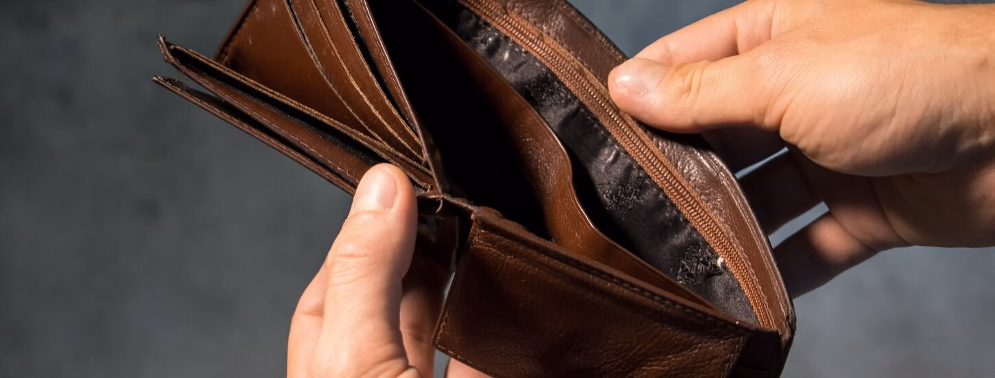 Person holds empty wallet open.