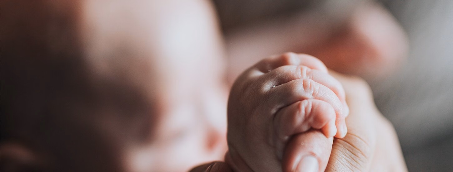 Person holding baby's hand