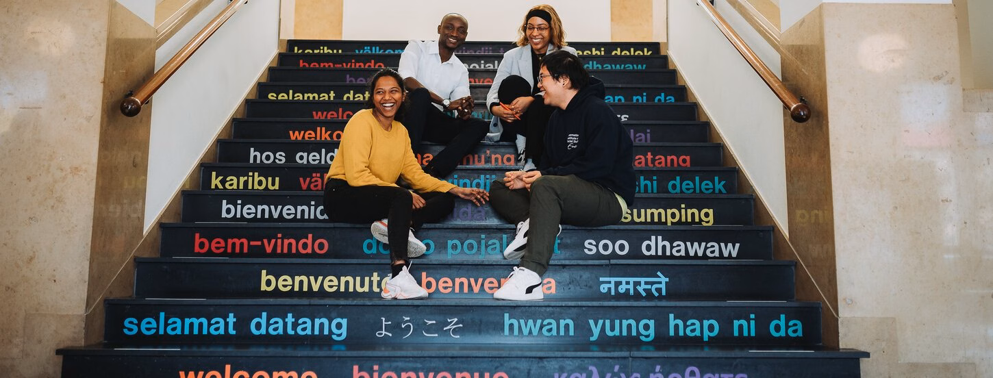 ISS students sitting on central staircase - 2023
