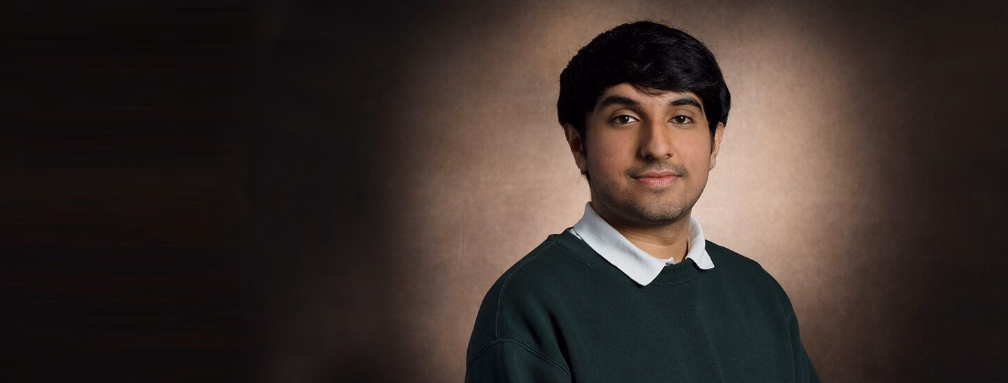 Student smiling with a closed smile at the camera