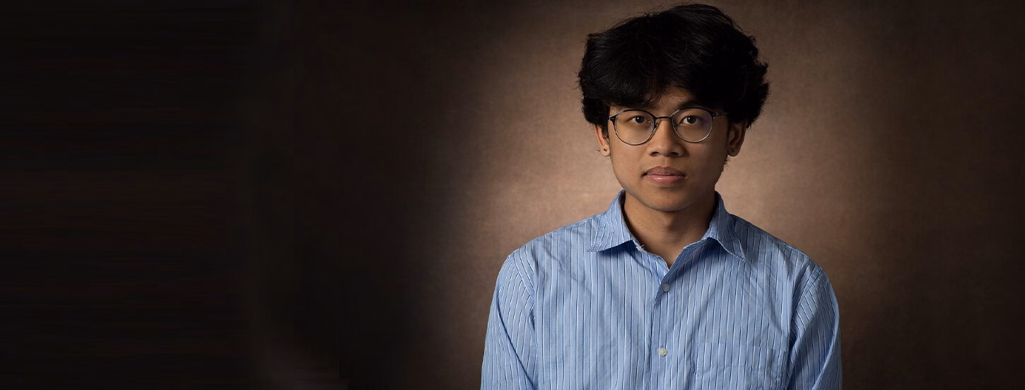 Student smiling with a closed smile at the camera