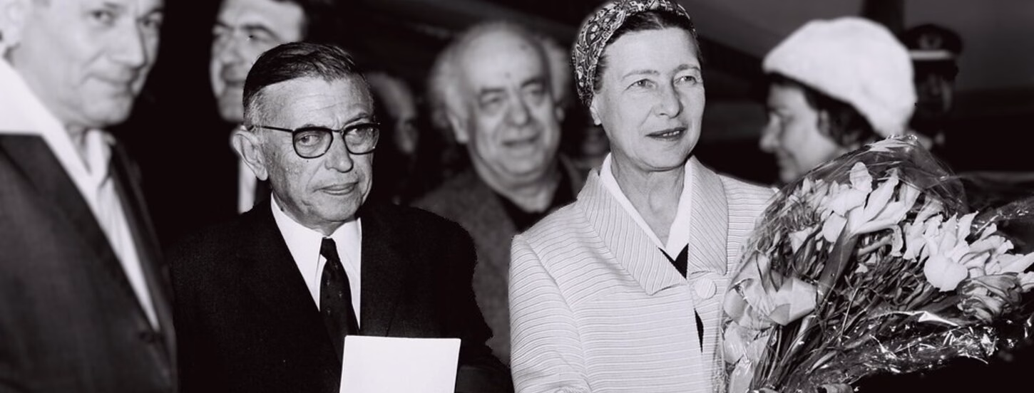 Woman holding a bouquet of flowers wrapped in plastic with man standing next to her. One man next to the woman is holding a paper in on eof his hands, black and white picture