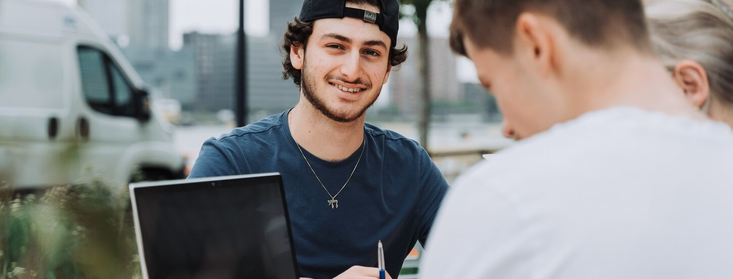 Students sitting outside with their laptop