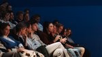 Prospective students sit in a lecture hall.