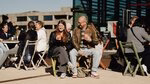 Daughter and father sit on a chair on campus during the bachelor's open day.