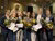 7 alumni met bossen bloemen en een certificaat voor het beeld van Erasmus in Erasmus Building