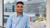 Student Giovanni Smargiasse poseert voor een raam met uitzicht op campus Woudestein
