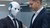 A humanoid robot in a suit with a person in a suit
