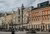 Zagreb city plaza framed by ornate historic stone and red brick buildings under cloudy sky