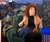 Curly red-haired woman in brown blazer gesturing during panel discussion on stage