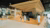 The Erasmus Education Lab, an open space with wood elements. In the space you can see people walking around and talking.