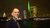 Guido Imbens in front of Erasmus bridge lit in green.
