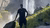 Man standing in front of waterfall