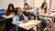 Four school children using their smartphone in the classroom