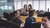 A workplace with several employees talking and working.
