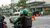 Man riding motor bicycle wearing a green helmet