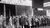 People standing outside on the street in line for the unemployed line to receive food