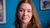 Annelisa looking into the camera in front of a blue cubic