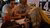 Two guys watching while girl writes on paper