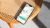 Op een bijzettafel ligt een telefoon met de ROOM app geopend