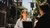 Two people talking on a sunny city street