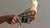 a hand holding three dollar notes that are on fire