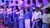 several students of the erasmus student choir on stage. they wear white and blue clothing.