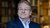 Portrait of Paul van Geest standing in front of a bookcase