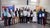 Een diverse groep professionals met certificaten op de foto, met op de achtergrond banners van de Wereldbank.