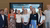 Twelve professionals in business attire smiling before a presentation screen in a conference room