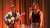 singer performs a heartfelt song, accompanied by a guitarplayer, in front of a red background