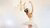 Ballerina dancing in a white gown around a golden chandelier